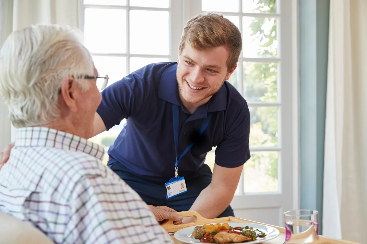 An All Care caregiver sharing a warm moment with a senior client at home in the Bronx